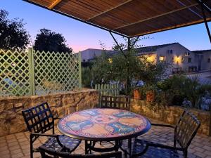 een patio met een tafel en stoelen en een hek bij Masseria Boscorotondo in Scicli