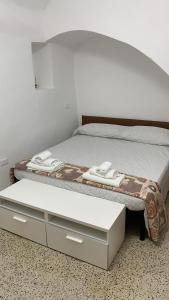Un dormitorio con una cama con un cajón y una mesa en Rifugio dei Saraceni en Vallecrosia