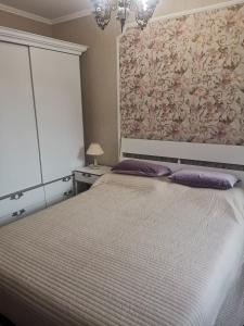 a bedroom with a large bed with purple pillows at Luxury apartment Amalfi 300 m from the beach in Varna City