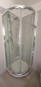 W łazience znajduje się prysznic ze szklanymi drzwiami. w obiekcie Stella Azzurra w mieście Porto Recanati