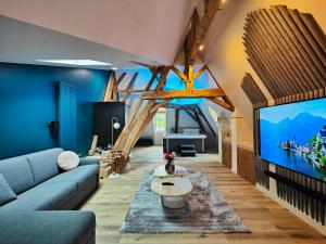 a living room with a couch and a tv at LE BAS CHITRAY in Ménil