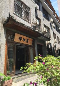 ein Gebäude mit einem Schild auf der Vorderseite in der Unterkunft Hemu House in Fenghuang