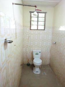 La salle de bains est pourvue de toilettes et d'une fenêtre. dans l'établissement Mgeni Homestay, à Kilindoni