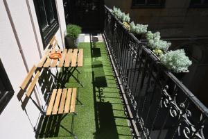 a patio with two benches and plants on a balcony at Akacfaapartman in Budapest