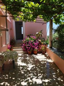 a house with flowers and plants on a balcony at Garden Of Olive Trees in AsfendhilÃ©s