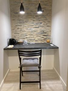 a black counter with a chair at a table at La Maison du Cocher - Chambre indépendante climatisée en Hypercentre - Lit Queen Size in Angers