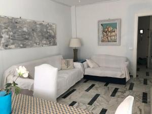 een woonkamer met een bank en 2 stoelen bij Giusy near the sea in Sanremo