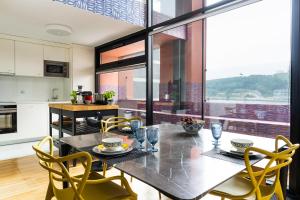 - une cuisine et une salle à manger avec une table et des chaises dans l'établissement Porto Insight Apartment River View - Pool & Garage, à Porto