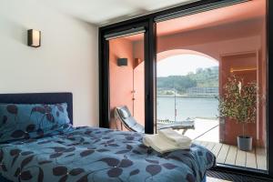 sypialnia z łóżkiem i widokiem na wodę w obiekcie Porto Insight Apartment River View - Pool & Garage w Porto