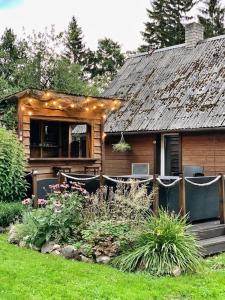 une maison avec une terrasse couverte dotée de chaises et un jardin dans l'établissement Lihtne majake asukohas Valma, à Valma