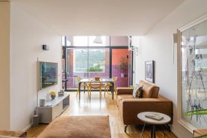 - un salon avec un canapé et une table dans l'établissement Porto Insight Apartment River View - Pool & Garage, à Porto