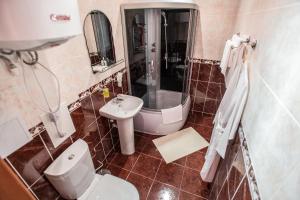 a bathroom with a toilet and a sink at Hotel Benefit in Perm