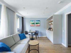numa I Artol Rooms & Apartments في دوسلدورف: غرفة معيشة مع أريكة وطاولة