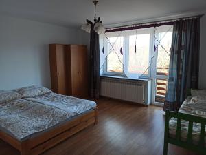 a bedroom with a bed and two windows at Rodzinne Zacisze Bysina in Bysina