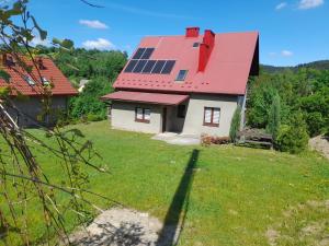 a house with a red roof with solar panels on it at Rodzinne Zacisze Bysina in Bysina