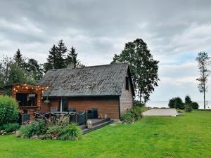 une petite maison en briques dans un champ d'herbe dans l'établissement Lihtne majake asukohas Valma, à Valma