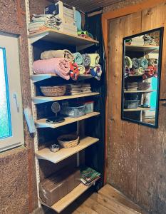 - un placard avec des étagères, des bols et des paniers en bois dans l'établissement Lihtne majake asukohas Valma, à Valma