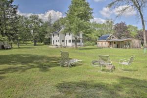 a group of chairs sitting in the grass in front of a house at Spacious and Modern Ashley Falls Home on 1 Acre 