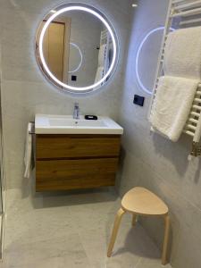 a bathroom with a sink and a mirror and a stool at Move in Miragaia in Vigo