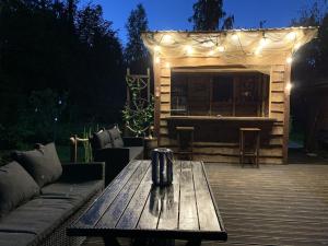 une table en bois assise sur une terrasse avec un bar dans l'établissement Lihtne majake asukohas Valma, à Valma