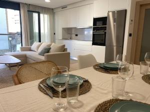 a kitchen and living room with a table with wine glasses at Move in Miragaia in Vigo