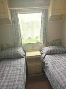 a bedroom with two twin beds and a window at Klarysewo in Mrągowo