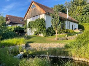 a house with a pond in front of it at Haus Garten der Seele in Neusiedl bei Güssing