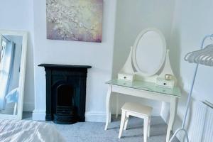 a bedroom with a dressing table with a mirror and a chair at Cosy 2 bed terraced house in Conwy in Conwy