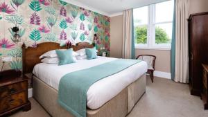 a bedroom with a large bed with a floral wallpaper at Sunbank House Metro Hotel in Perth