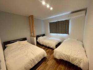sypialnia z 2 łóżkami i oknem w obiekcie Doublerainbow Resort Katsuura w mieście Katsu’ura