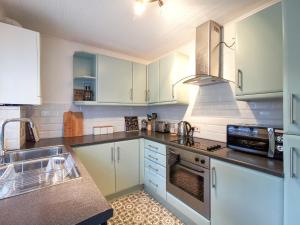 een keuken met witte kasten en een fornuis met oven bij Week2Week SEASIDE 2 BEDROOM APARTMENT - Free Parking, WiFi in Westoe