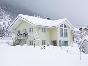 a house covered in snow with snow at Ferienwohnung Schmidt in Aschau im Chiemgau