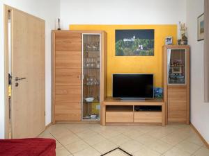a living room with a television on a wooden entertainment center at Ferienwohnung Schmidt in Aschau im Chiemgau