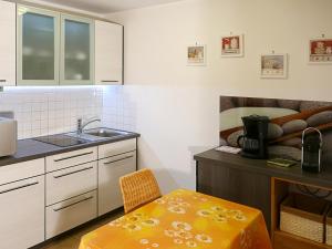 a kitchen with a sink and a table with a chair at Ferienwohnung Schmidt in Aschau im Chiemgau