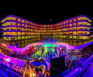 a large building with people in front of it at night at The Tower by Temptation Cancun Resort - All Inclusive - Adults Only in Cancún