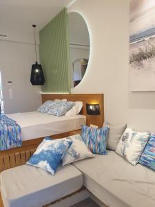 a room with two beds and a couch and a mirror at Vista Al Mare Luxury Apartments in Gialova