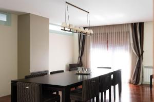 a dining room with a black table and chairs at Villa Medroa in Faia