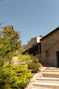 um edifício de pedra com escadas ao lado de uma árvore em Villa Medroa em Faia