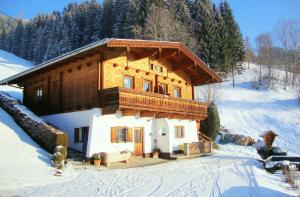 una cabaña de madera en la nieve cubierta de nieve en Appartementhaus Eberharter, en Hart im Zillertal