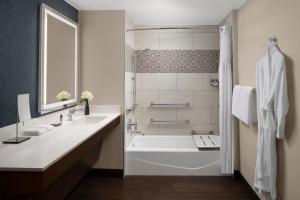 a bathroom with a tub, sink and mirror at Hyatt Regency Westlake in Westlake Village