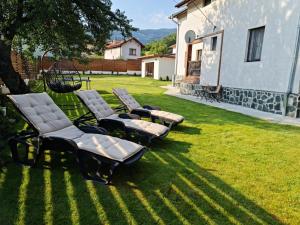 a group of chaise lounge chairs sitting on a lawn at Algarte Guest House in Madzhare