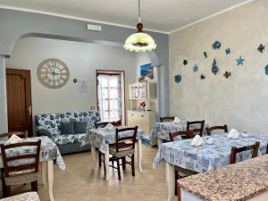 ランペドゥーザにあるBed and Breakfast Siciliamuri Lampedusaのダイニングルーム(テーブル2台、ソファ付)