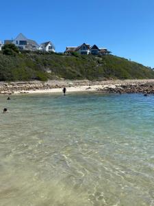 a beach with people swimming in the water at Luxury Beach House in St Francis Bay