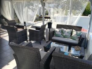 un patio con sillas de mimbre y una mesa de cristal en Magnolia Senses, en Kini