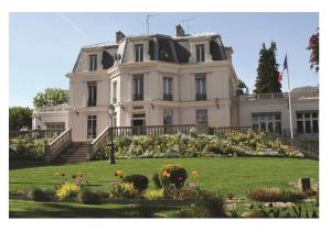 una grande casa bianca con un giardino di fronte di Superbe appart 2 pièces -accès autonome- avec parking gratuit a Chaville