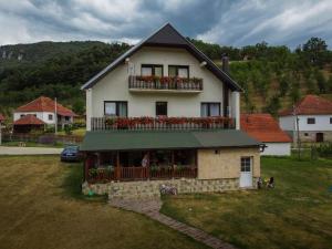 una casa con un balcón con flores rojas. en Taorska Vrela -Jovanović, en Valjevo