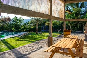 einen Picknicktisch aus Holz auf einer Terrasse mit einem Pool in der Unterkunft Casa Lima in Coucieiro