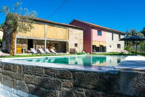 einen Pool in einer Steinmauer neben einem Haus in der Unterkunft Casa Lima in Coucieiro