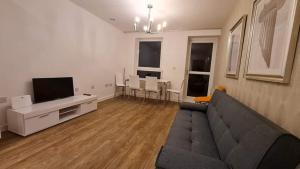 a living room with a couch and a flat screen tv at Empress at College - Spacious 2 bedroom apartment in Southampton