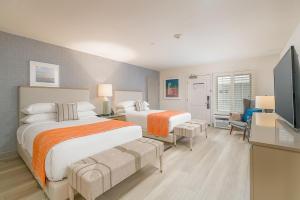 a bedroom with two beds and a flat screen tv at Beach Terrace in Carlsbad